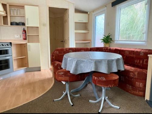 a living room with a table and a couch at Cabin by Beach & Nature Reserve Mon & Fri Check in Days Swanpool Falmouth Cornwall in Falmouth