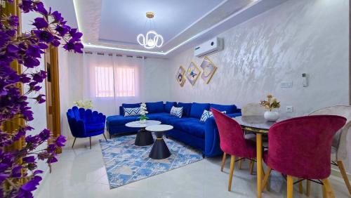 a living room with a blue couch and a table and chairs at Elite Holiday Home - Luxury & Centric Flat in Tangier