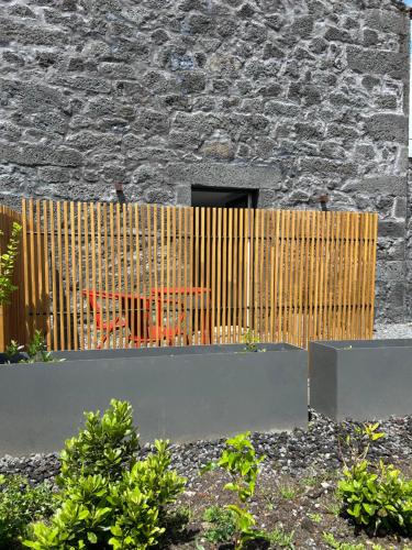 a wooden fence in front of a building at Cá Por Casa Pico-Faia in Prainha de Baixo