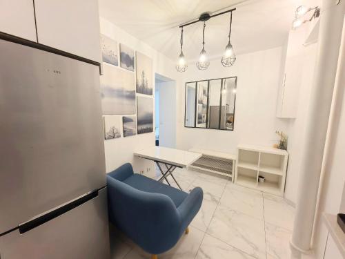 une chambre avec une chaise bleue et une table dans l'établissement Marais Side Apartment Paris 11e, à Paris