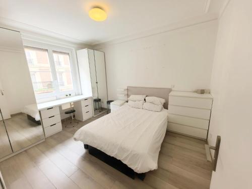 une chambre avec un lit, un bureau et une fenêtre dans l'établissement Marais Side Apartment Paris 11e, à Paris