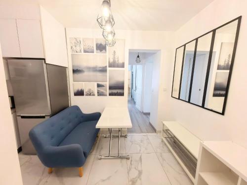 une cuisine avec une chaise bleue et une table dans l'établissement Marais Side Apartment Paris 11e, à Paris