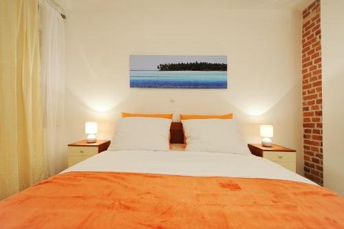 een slaapkamer met een groot bed met 2 lampen bij Little Cosy Apartment in Zadar