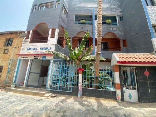 a building with a palm tree in front of it at Ndiamala in Darou Rhamane