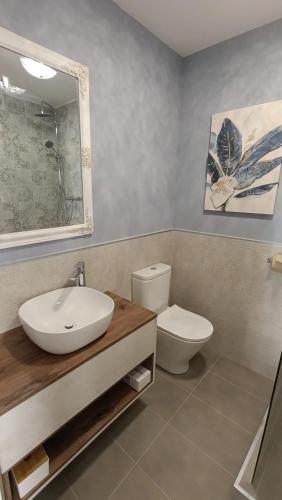 a bathroom with a sink and a toilet and a mirror at Roko's in Hvar