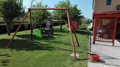 a playground with a swing set in the grass at Agriturismo Il Melograno in Tessera
