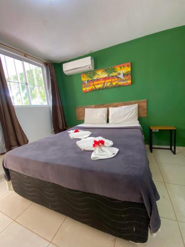 a bedroom with a bed with two towels on it at Pousada Porto de Amigos in Porto De Galinhas