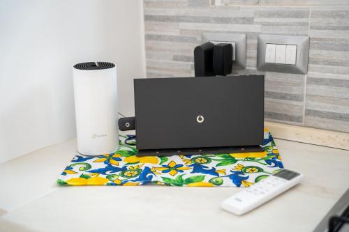 a laptop sitting on a table with a remote control at The Cave On The Sea in Meta