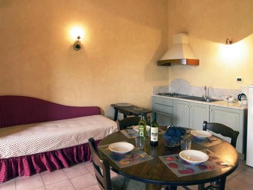 a room with a table and a bed and a kitchen at Agriturismo Bellavista in San Miniato