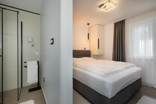 Un dormitorio con una cama blanca y un espejo. en Apartments by the sea Baska, Krk - 24433, en Baška