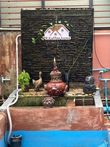a water fountain with a bird and a house at บ้านสวนรัญจวนสาขาสุราษฎร์ธานี in Ban Huai Chiat