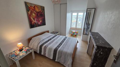 une chambre avec un lit et une table avec une lampe dans l'établissement Appartement centre, vue sur Mer, proche Plages, à Douarnenez