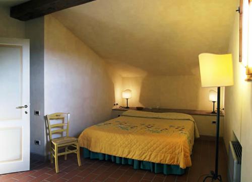 a bedroom with a bed and a chair at Agriturismo Bellavista in San Miniato