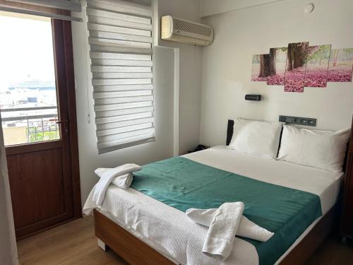 a bedroom with a large bed with a window at Hbs Hotel in Kuşadası