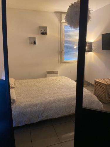une chambre avec un lit et une fenêtre dans l'établissement Appartement cosy et moderne, à Marseille