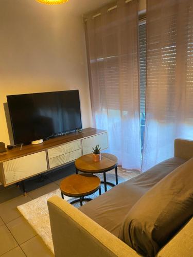 un salon avec une télévision à écran plat et un canapé dans l'établissement Appartement cosy et moderne, à Marseille