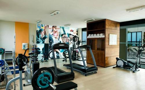 a gym with several tread machines in a room at Flat aconchegante in Brasilia
