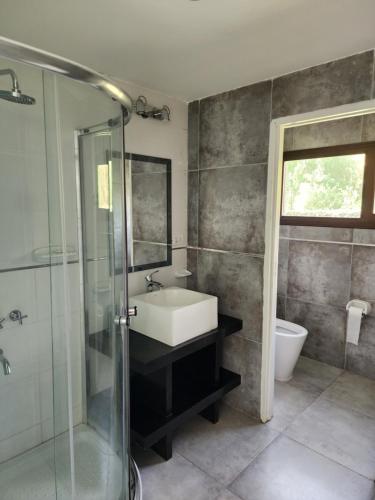 a bathroom with a sink and a glass shower at Casa Victoria - Valle Grande in San Rafael