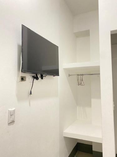 a flat screen tv hanging on a wall at Hostal Crisangel in Rivas