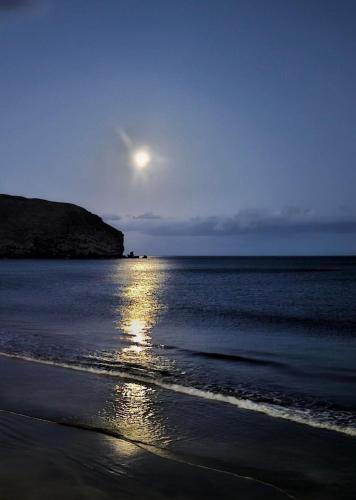 a moonrise over a beach with the ocean at Casa Mararía in Gran Tarajal