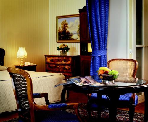 a living room with a table with a bowl of fruit on it at Hotel Ambassador in Vienna