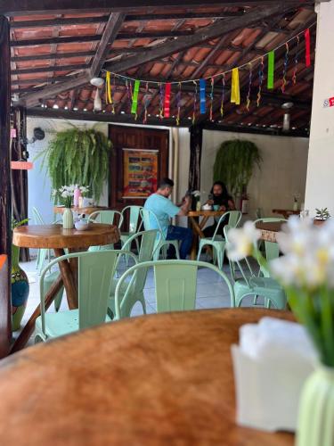 a group of people sitting at tables in a restaurant at Pousada Porto de Amigos in Porto De Galinhas