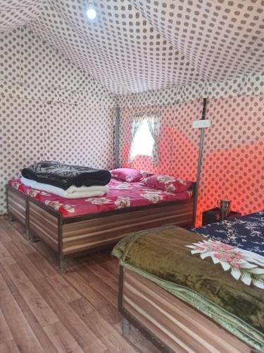 a bedroom with two beds in a tent at Balkhila bank cafe and camping in Gopeshwar
