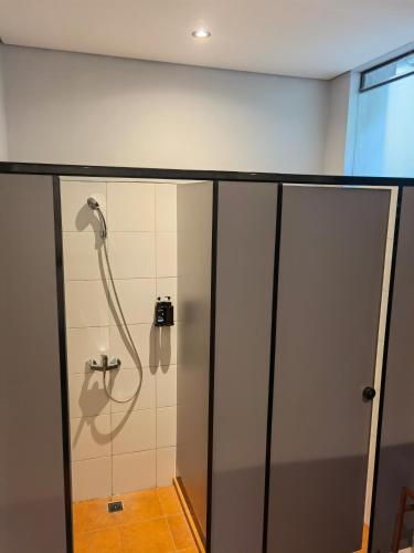 a shower in a bathroom with a glass door at Nala's Home in Uluwatu