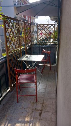 a table and two benches on a balcony with an umbrella at Comeacasa in Salerno