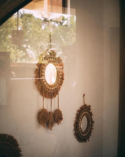 two wreaths on a wall next to a mirror at Villa Jivanaya in Isda Islet