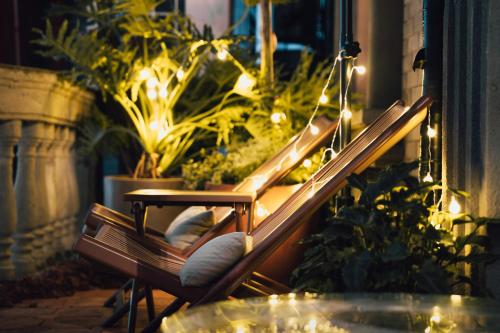 a bench with lights on a balcony with plants at 归相Golden Age酒店 in Chengdu
