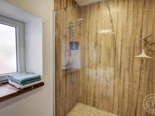 a bathroom with a shower with a wooden wall at Gîte charmant avec 2 chambres et jardin, tout équipé en campagne avec Wi-Fi et parking gratuit - FR-1-496-226 in Amions