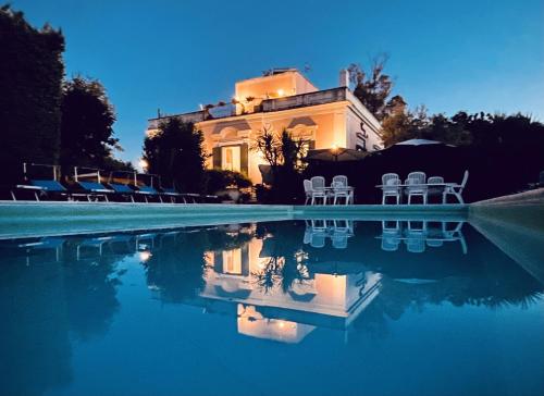 a house with chairs and a swimming pool at night at Il Podere in Trani