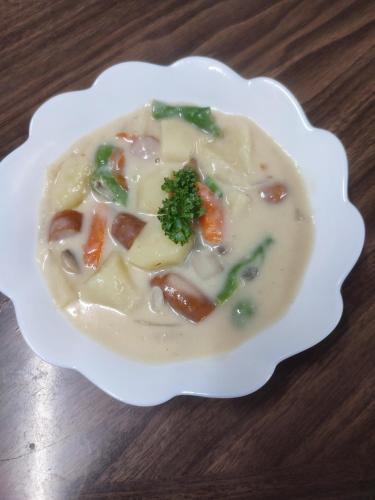 a bowl of soup on a wooden table at 北軽井沢 あさま1155 in Tsumagoi