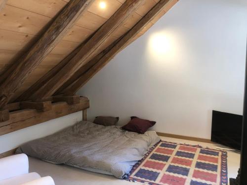a bed in the corner of a room at Sérénité et Nature dans une ferme équestre - loft lumineux de 140m2 in Massonnens
