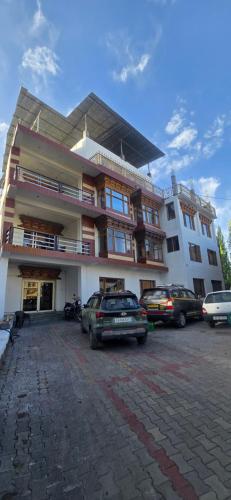 a large building with cars parked in a parking lot at The White Yak Hotel in Leh