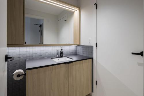 a bathroom with a sink and a mirror at Smithe House in Vancouver