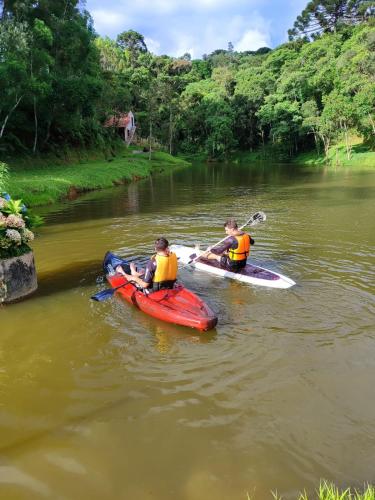 two people in kayaks on a river at Pousada Reserva Verde in Quatro Barras