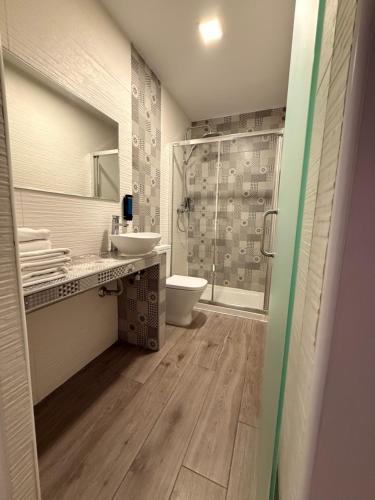 a bathroom with a toilet and a sink and a shower at HOSTAL LETTO DAL MARE in Valencia
