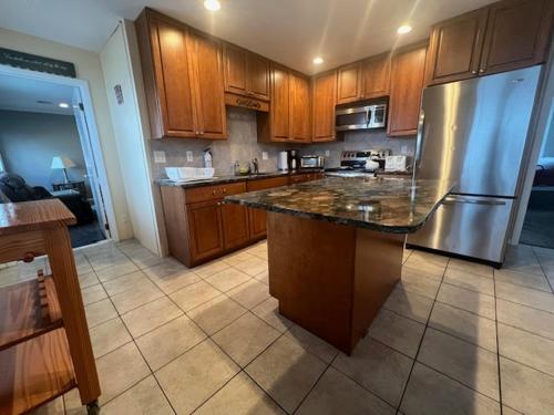 a kitchen with wooden cabinets and a stainless steel refrigerator at 1BR Condo One Block from Sea-Balcony in Seaside Heights