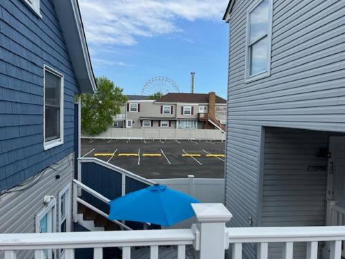 a blue umbrella sitting on a porch with a parking lot at 1BR Condo One Block from Sea-Balcony in Seaside Heights