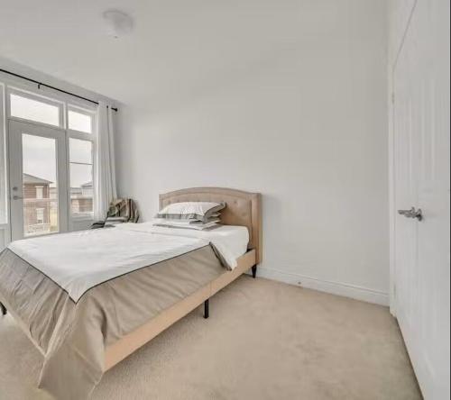 a bedroom with a bed and a large window at Cambridge Luxury by Ravine in Cambridge