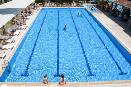 a large swimming pool with people in the water at Belkon Hotel in Belek