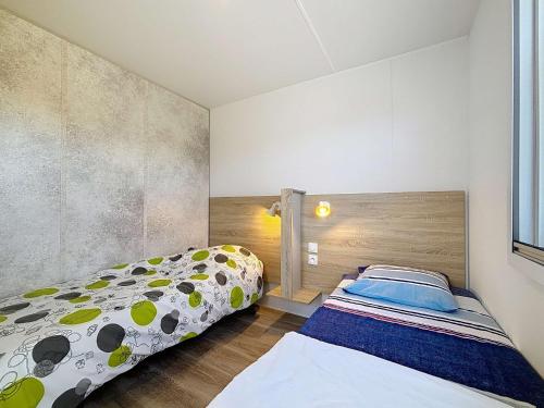 une chambre avec deux lits dans une pièce dans l'établissement Mobil-home Keywest: 2 chambres, 2 sdb, plage à 200m, piscine chauffée, fitness, parking, Wi-Fi inclus - FR-1-361A-27, à Jullouville