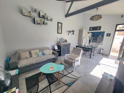 un salon avec un canapé et une table dans l'établissement Maison rénovée avec jardin et terrasse au cœur de La Chaume, proche plage, WiFi - FR-1-92-944, à Les Sables-dʼOlonne