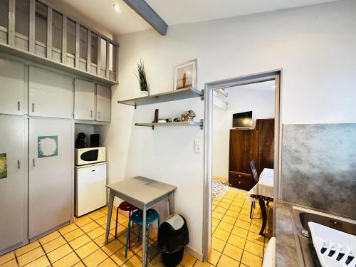 - une cuisine avec une table et une petite table dans l'établissement Maisonnette à Fouras proche plage, 2-3 pers - FR-1-709-97, à Fouras