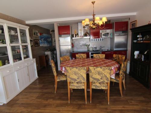 une salle à manger avec une table et des chaises et une cuisine dans l'établissement Appartement 3 pièces pour 8 à L'Alpe d'Huez avec terrasse - FR-1-405-370, à Huez