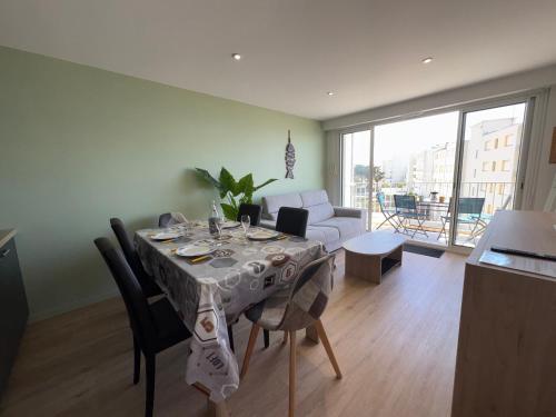 un salon avec une table avec des chaises et un canapé dans l'établissement Appartement rénové à 50m de la mer pour 6 pers. - FR-1-323-579, à Saint-Jean-de-Monts