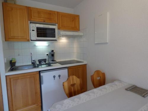 une petite cuisine avec un évier et un micro-ondes dans l'établissement Studio rénové 4 pers - accès direct aux pistes - FR-1-458-224, au Grand-Bornand