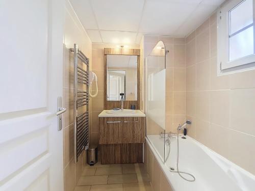 une salle de bain avec une baignoire, un lavabo et un miroir dans l'établissement Callian : Appartement sécurisé près du Lac, animaux admis - FR-1-779-12, à Callian